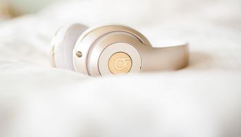 gold edition Beats by Dr.Dre wireless headphones on top of white textile
