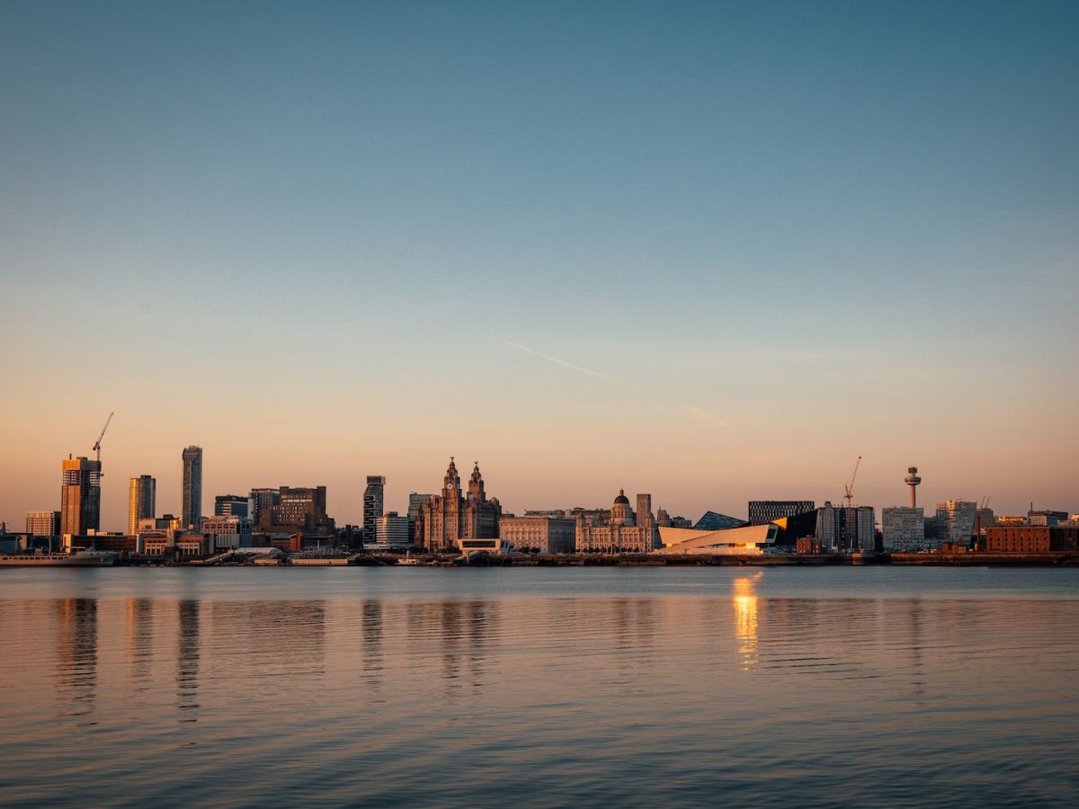 city skyline across body of water during sunset
